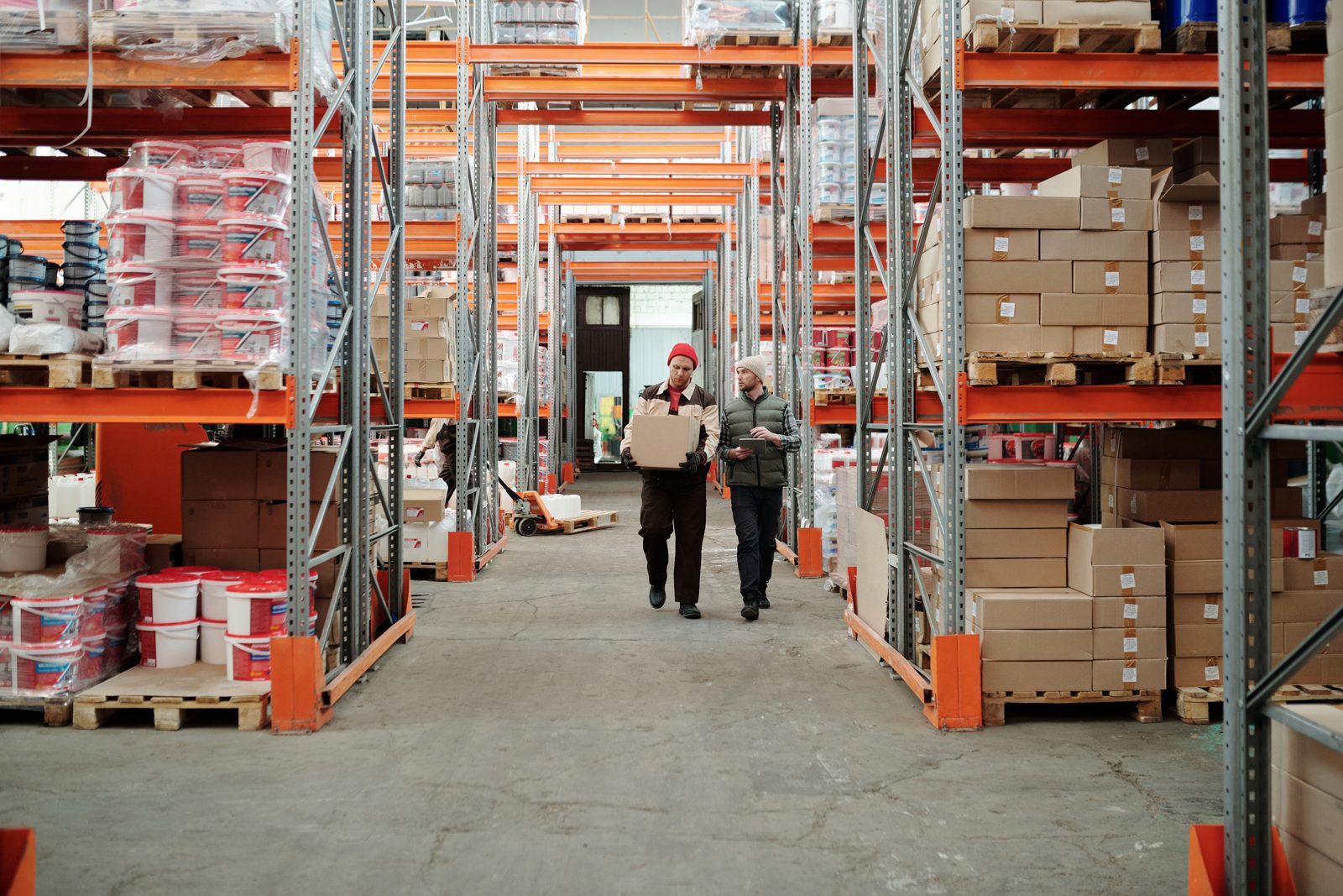 Tall warehouse racks stacked with boxes and products in a fulfillment center aisle